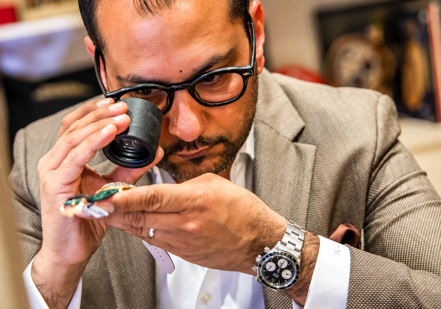Tariq Malik inspecting a watch through a loupe