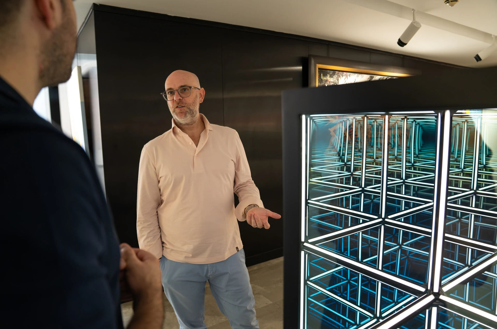 Mirrored cube sculpture being discussed at Opera Gallery DIFC